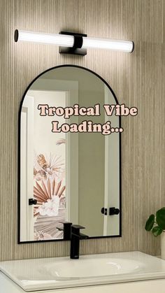 a bathroom mirror with the words tropical vibe loading on it