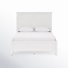 a white bed with two pillows on top of it and an open drawer underneath the headboard