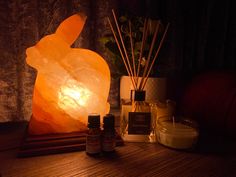 a lamp that is sitting on top of a table next to some bottles and candles