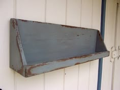 an old metal shelf hanging on the side of a building