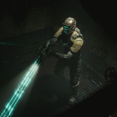 a man in a gas mask holding a green laser light while kneeling down on a platform