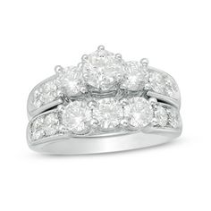 a white gold wedding ring set with three stones on each side and two rows of diamonds in the middle