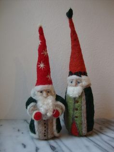 two christmas gnomes sitting next to each other on top of a white countertop