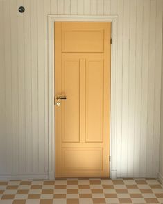 an empty room with a yellow door and checkered flooring on the floor is shown