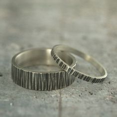 two wedding rings sitting on top of each other