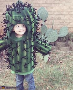 a little boy dressed in a cactus costume