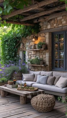 an outdoor living area with couches, tables and potted plants