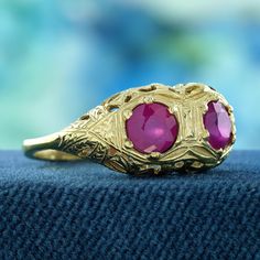 Adorn your fingers with this exquisite Natural Double Ruby Edwardian Style Filigree Solid Gold Ring. Crafted from solid yellow gold, this stunning piece showcases two vibrant natural rubies, set against a beautifully intricate filigree design that echoes the sophistication of the Edwardian era. With a carefully balanced size that fits comfortably on the hand, this ring makes a striking statement while still being versatile enough for everyday wear. CHARACTERISTICS Status: Made to order Origin: Thailand Metal: Solid 9K Yellow Gold Ring Size: US 3-8 Total Gemstones Weight: 1.00 carat. (approx.) Total Gram Weight: 2.90 g. (approx.) *Pictures have been enlarged to show details* PRIMARY STONE(S) Stone: Natural Ruby Color: Red Shape: Round Size: 5 mm. Number: 2 Weight: 1.00 Carat (approx.) An at Traditional Oval Ruby Ring For Anniversary, Antique 14k Gold Ruby Ring With Intricate Design, Antique Diamond Cut Ruby Ring For Anniversary, Antique Ruby Ring With Filigree For Anniversary, Antique Ruby Ring With Diamond Cut For Anniversary, Yellow Gold Ruby Ring With Intricate Design For Promise, Fine Jewelry Yellow Gold Ruby Ring With Intricate Design, Antique 14k Birthstone Ring For Anniversary, 14k Yellow Gold Ruby Ring With Intricate Design