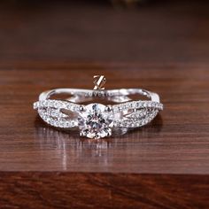 a diamond ring on top of a wooden table with the word love written on it