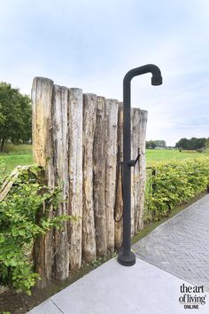 a black faucet sitting next to a wooden fence