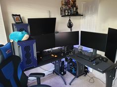 three computer monitors sitting on top of a desk next to a keyboard and monitor screen