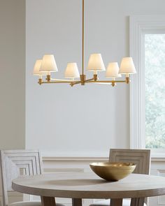 a dining room table and chairs with a bowl on the table in front of it