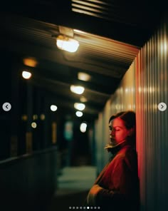 a person standing next to a wall in the dark