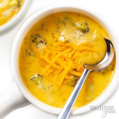 a bowl of broccoli cheese soup with a spoon