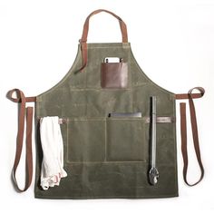 a green apron with tools hanging from it's front and side pockets on the back