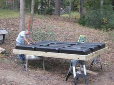 a man is working on some kind of thing in the woods with his hands together