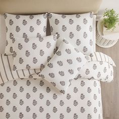 a bed with white and grey hearts printed on the comforter, pillows and pillow cases