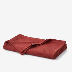 a folded red blanket on a white background