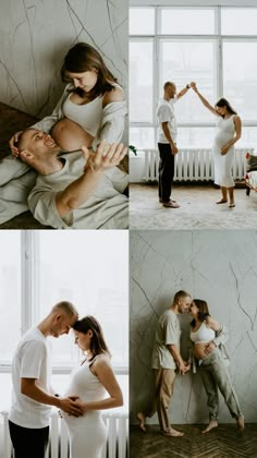 a man and woman kissing in front of a window with their baby bumping her belly