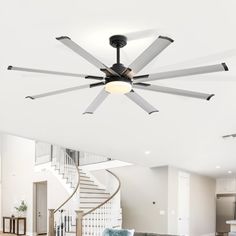 a living room filled with furniture and a ceiling fan in the middle of a room