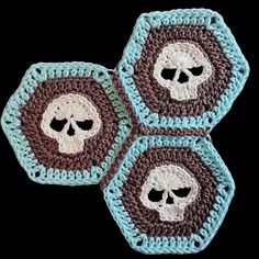 three crocheted coasters with skulls on them