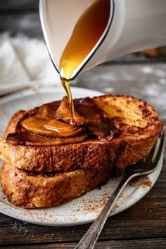 french toast with caramel sauce being drizzled over it on a plate