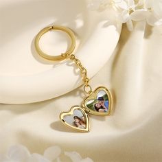 two hearts shaped keychain on top of a white plate with flowers in the background