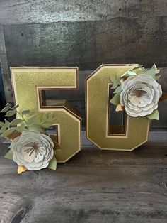 the number 50 is decorated with flowers and leaves