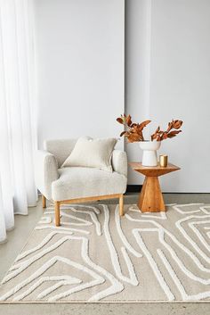 a living room with a chair, table and rug