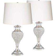 two crystal lamps with white shades on them