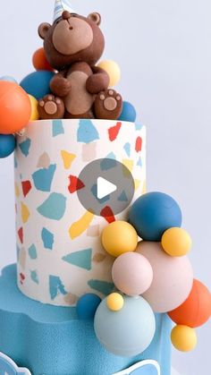 a teddy bear sitting on top of a birthday cake