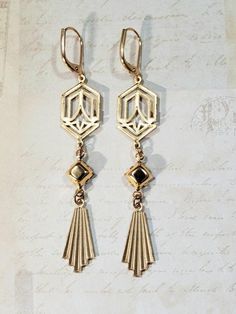 These modern Deco earrings are a great example of classic 1920s style. They feature Art Deco style brass connectors, vintage black beads, and brass fan shaped charms.The brass connectors and charms have a textured front and a back that is the hollow reverse of the front. (SEE 2nd PHOTO)They are extremely lightweight and comfortable to wear.The earrings measure 2 3/4 inches long from the top of the ear wires to the bottom of the pendants.Perfect for everyday or evening.ABOUT THIS COLLECTIONWhat a Green And Gold Art Deco, Green And Gold Art, Flapper Jewelry, Art Deco Jewelry 1920s, Black And Gold Art Deco, 1920s Earrings, Black And Gold Art, October Jewelry, Gold Art Deco Earrings