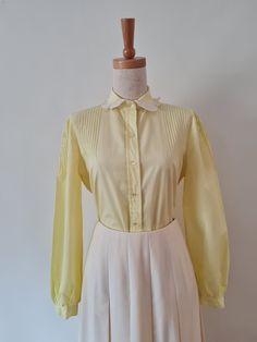 Cap Ferrat lovely 1970's lemon long sleeved cotton blouse by Cap Ferrat.  Pintucked details across shoulder and along top edge of sleeves.  This has a lovely Peter Pan collar with pleated contrast white georgette at collar edge.  A button through placket and softly gathered sleeve into a narrow cuff complete this beauty.  No size estimate this to be a size 8-10, but please check measurements. Lemon with white trim. 100% Cotton Imported fabric. Excellent Condition Body Length from HPS -  64cm  Sl Vintage Long Sleeve Blouse For Spring, Vintage Fashion Spring Blouse With Lace Trim, Spring Retro Top With Lace Collar, Spring Vintage Fashion Blouse With Lace Trim, Retro Cotton Blouse With Lace Collar, Vintage Yellow Top With Ruffles, Vintage Yellow Ruffled Top, Retro Long Sleeve Blouse With Lace Collar, 1970s Cotton Blouse For Spring