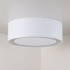 a white lamp hanging from the ceiling in a room with no one around it,