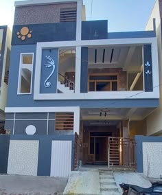 a motorcycle parked in front of a blue and white building with stairs leading up to the second floor