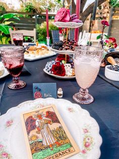 a table topped with plates and glasses filled with food next to each other on top of a blue cloth covered tablecloth