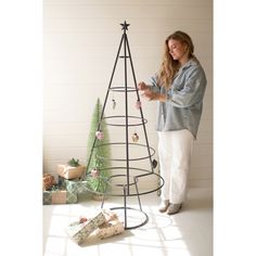 a woman standing next to a christmas tree