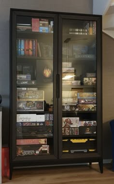 a book case with many books inside of it on top of a hard wood floor