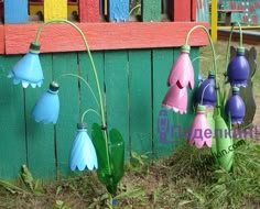 colorful umbrellas are hanging on the side of a wooden fence in front of a green wall