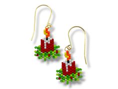 the earrings are made out of legos and have green leaves on them, as well as an orange flower