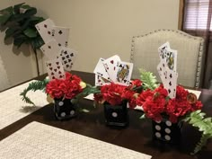 flowers and cards are sitting in black vases on a table