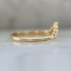 Why I Love It: This delicate tiara band makes a wonderful addition to your stack or on its own. Seven high quality white round brilliant cut diamonds are set into your choice of golds, and is perfect to pair with low profile rings. The Details: Available in: 14k Yellow Gold, 14k White Gold, 14k Rose Gold & 18k Peach Gold® Available in 18k & Platinum By Request Approximately .19 Carats of GH/VS White Round Brilliant Cut Diamonds Band Width is Approx. 1.80 mm Made to order in your size, please all V Shaped Stacking Ring, Delicate Tiara, Curved Yellow Gold Rings With Polished Finish, Yellow Gold Curved Wedding Band, Tiara Diamond, Diamond Shop, Diamond Band, Lab Diamonds, Round Brilliant Cut Diamond