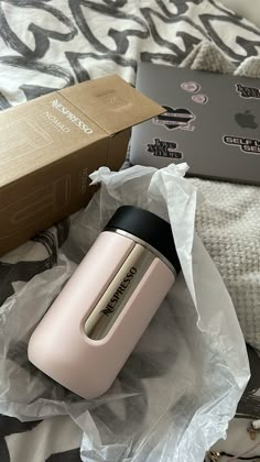 an open box sitting on top of a bed next to a pink hair dryer