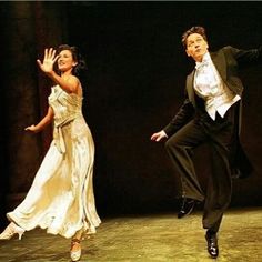 two people dressed in formal wear, one is dancing and the other is wearing a dress