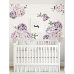 a baby's room with flowers on the wall and a crib in front