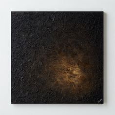 an abstract painting with black and gold colors on the surface is shown in front of a white wall