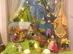 a table topped with candles and figurines next to a tree