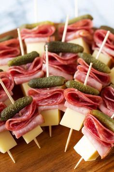 many different types of food are arranged on skewers with pickles and cheese