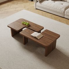 two wooden tables sitting on top of a carpeted floor next to a white couch