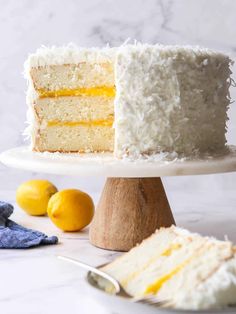 a close up of a slice of cake on a plate with lemons in the background